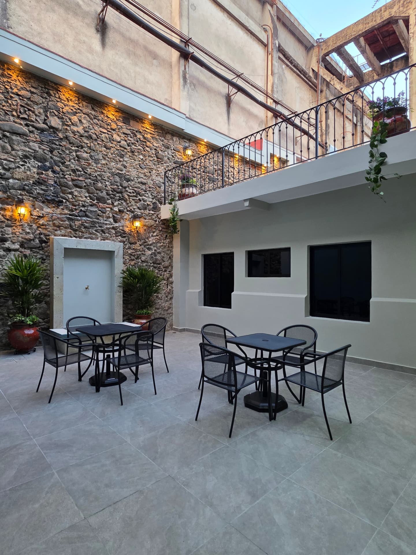 Patio con muro de piedra e iluminación cálida